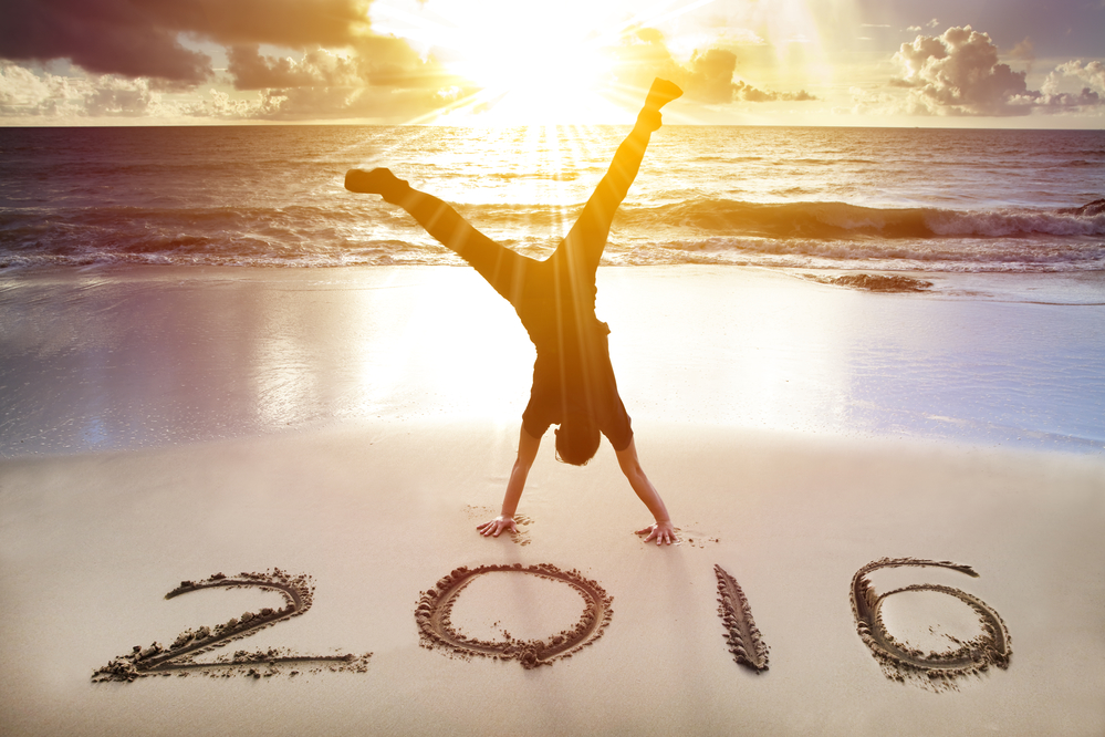happy new year 2016. young man handstand on the beach